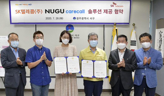 지난 28일 SK텔레콤 이현아 AI서비스단장과(왼쪽) 서대석 서구청장이 '누구 케어콜'의 광주광역시 서구 도입 협약을 맺은 후 기념 촬영을 하고 있다. SK텔레콤 제공